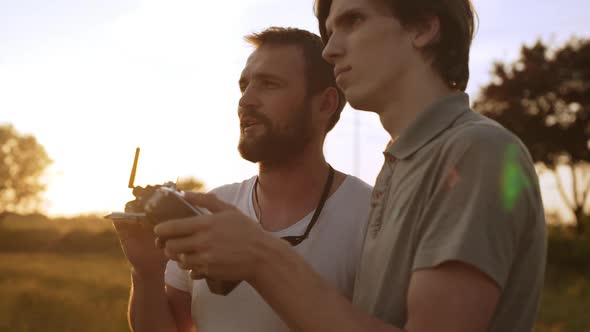 Close Up of Father Teaching Son Flying Drone Young Man Operating Quadrocopter Controller While