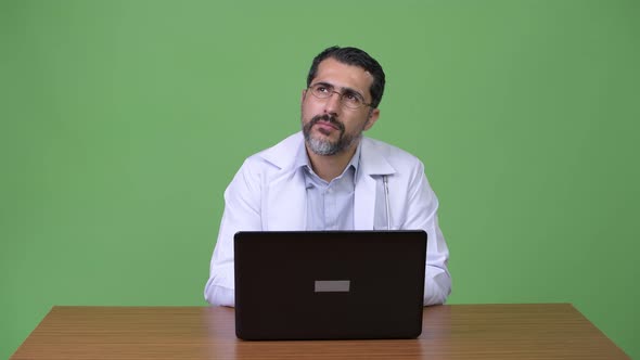 Handsome Persian Bearded Man Doctor Thinking While Using Laptop