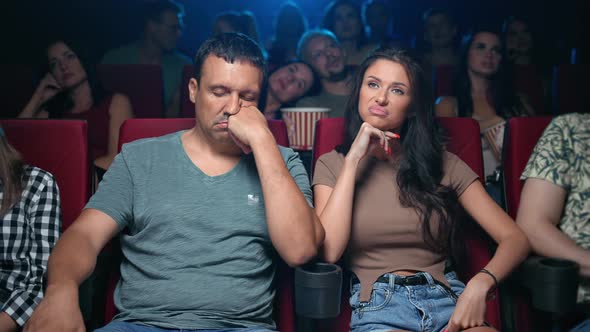Bored Couple Sleeping at Uninteresting Movie with Unpleasant Face Expression Sitting on Armchair Row alt