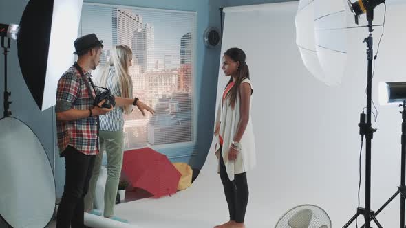 Behind the Scenes on Photo Session: Assistant Giving Model a Bar High Chair alt