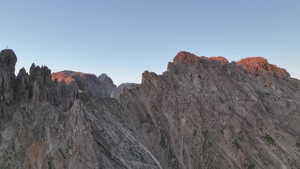 Dolomites mountains peaks with a hiking path on a summer sunrise alt