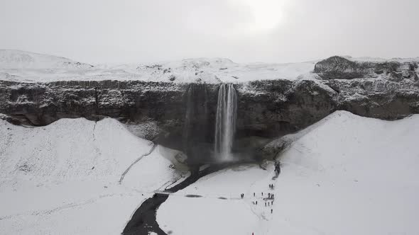 Aerial view of Seljalandsfoss waterfall in Iceland covered by snow