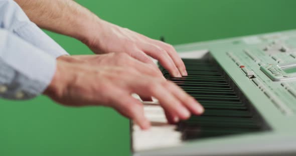 Side view of a man playing the keyboard alt