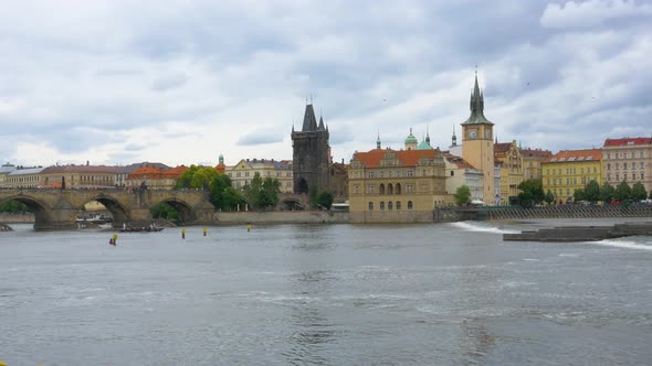 Panning view of Old Town Prague clock tower on the shore of Vltava River alt