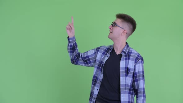 Happy Young Handsome Hipster Man Talking While Pointing Up alt
