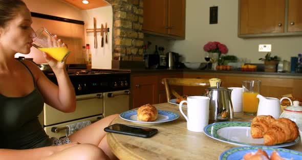 Woman having juice while using mobile phone 4k alt