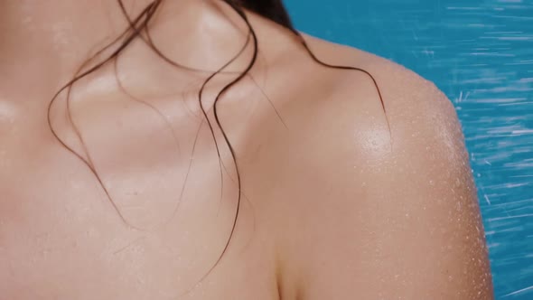 Woman Back and Shoulder Getting Water Splashes on Blue Background alt