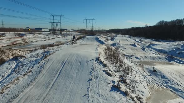 a motorcyclist performs stunts on a winter track alt