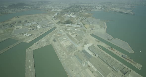 Foggy helicopter aerial moving from suburban area to urban area, day alt