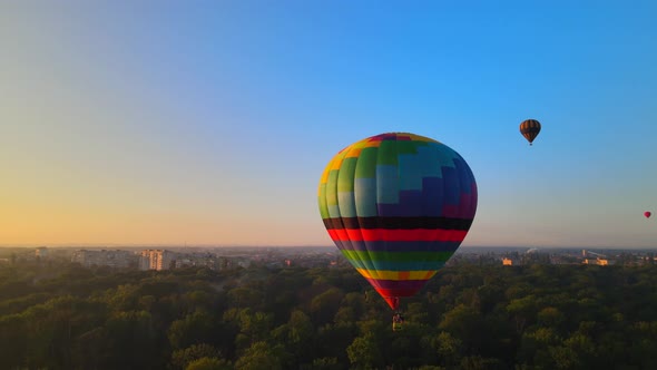 Aerial Drone HDR View of Colorful Hot Air Balloon Flying Over Green Park in Small European City at alt