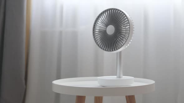 White Desktop Electric Fan on Light Wooden Table