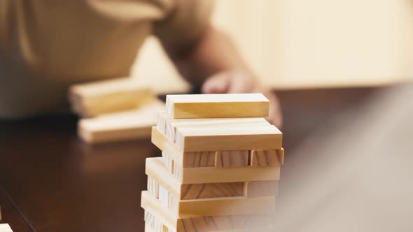 Child and adult man moving Jenga bricks