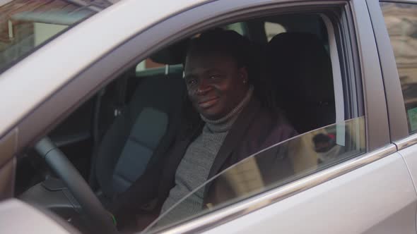 Excited African American Black Man Showing Thumb Up While Sitting on Driver Seat of His New Car alt