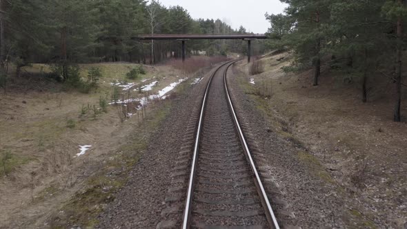 AERIAL: Slow Flight Over Railway Tracks Towards Overpass Bridge