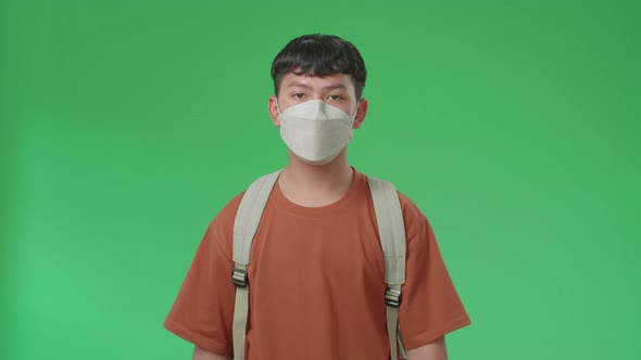 Asian Boy Student Wearing A Mask, Walking To School On Green Screen alt