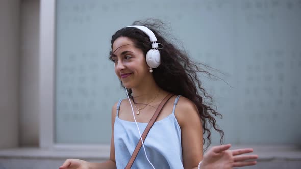 Happy Hipster Girl with Headphones Listening to Music and Dancing