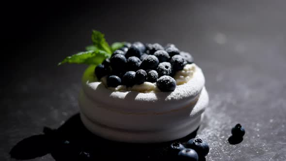 Mini Meringue Dessert Pavlova Cake with Fresh Blueberries Plased on Dark Rusty Table