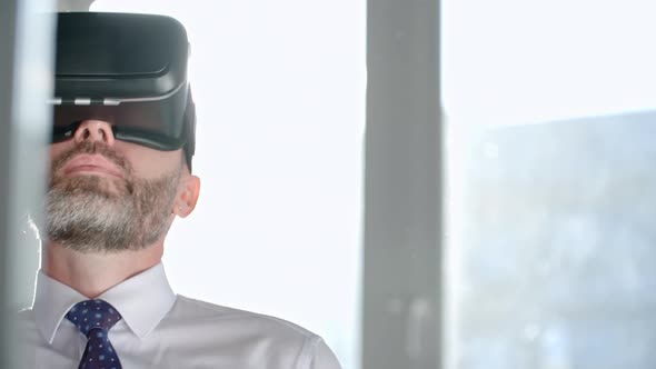 Businessman in VR Goggles Talking on Phone alt