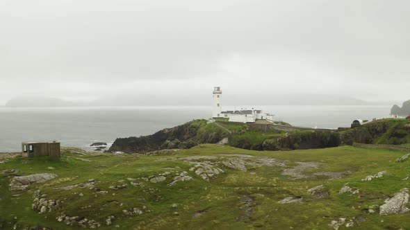 Aerial establishing shot of solitary lighthouse at Fanad Head, northern Ireland alt