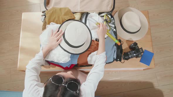 Woman Traveller Packing Clothes In A Suitcase For A New Journey. Luggage For Travel alt