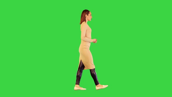 Robotic Girl in Beige Dress Walks Making a Slight Nod on a Green Screen Chroma Key