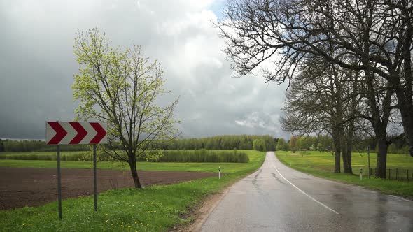 Traffic sign on a road bend in spring