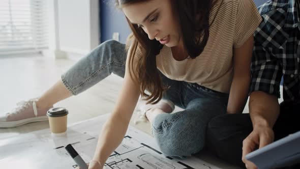Tracking video of couple looking at blueprint in new house. Shot with RED helium camera in 8K alt