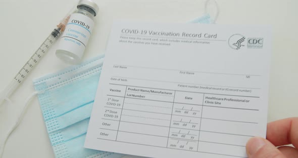 Medical Mask and COVID19 Vaccine Doctor Hand Put Vaccination Record Card Approved By CDC with Corona alt