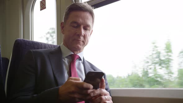 Commuter on his way to work looking at smart phone