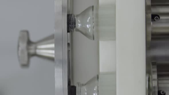 Vertical Video Glass Bottles Filled and Sealed with Rubber Caps on a Medical Solution Conveyor Line