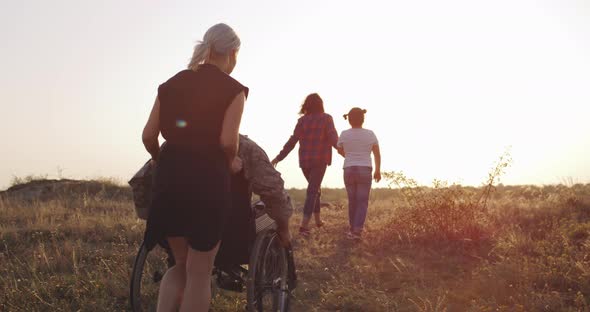 Soldier and Family Enjoying Afternoon on a Meadow alt
