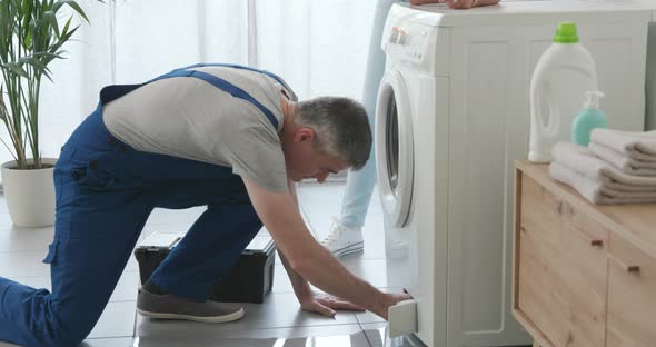 Plumber checking a leaking washing machine