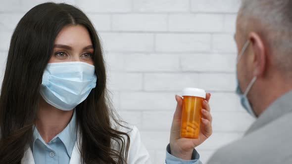 Female Doctor Prescribing Medication Pills To Senior Male Patient Indoors alt