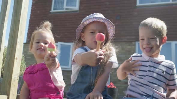 Three Cute Little Children Enjoys Delicious Ice Cream Cone alt