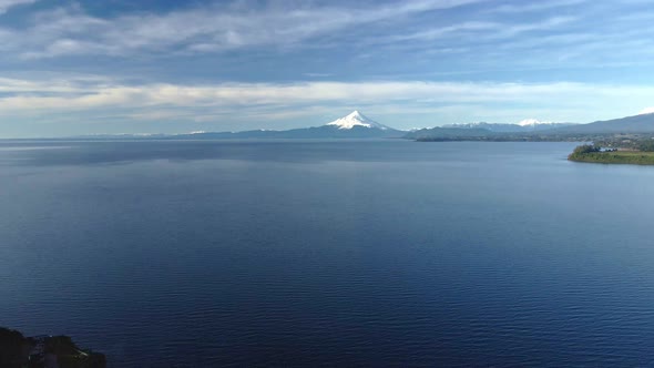 Dolly out aerial view of Lake Llanquihue with Osorno volcano in the background, Puerto Varas, Chile alt