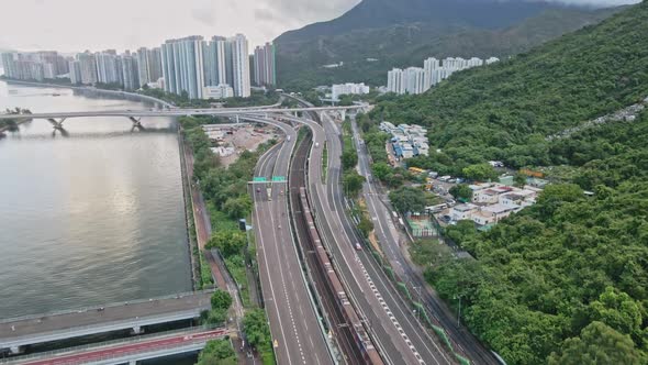 Drone shot of MTR Train and Highway traffic in Shatin, Hong Kong alt