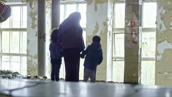 Muslim Woman with Children in Abandoned Building alt