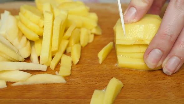 Cutting Potatoes By Knife on Table in Process of Cooking