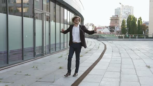 A successful and in a good mood businessman goes to his favorite job and listens to music alt