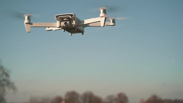 White Drone Hanging in Air or Flying on Nature Background. Slow Motion Shot.	
