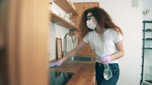 Gorgeous Lady Is Using Sanitizer To Clean the Kitchen alt