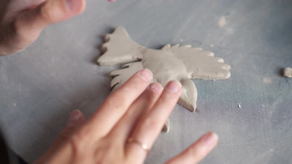 Close Up Top View of Potter Woman Hands Working on Details of a Clay Handcraft Bird alt