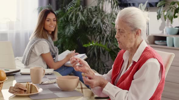 Grandmother Eating Dinner while Staying with Caregiver at Home