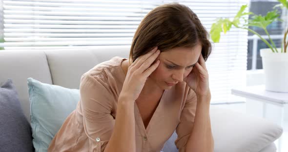 Sad woman thinking and touching her head alt