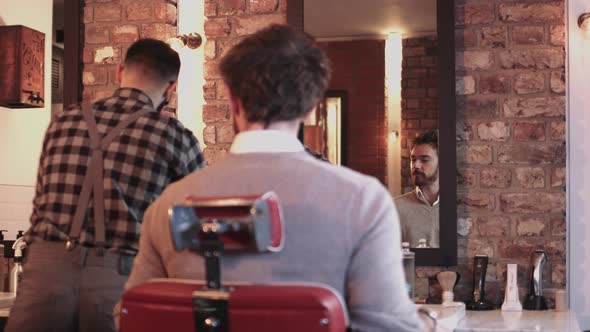 Young Adult Male having haircut in barbershop