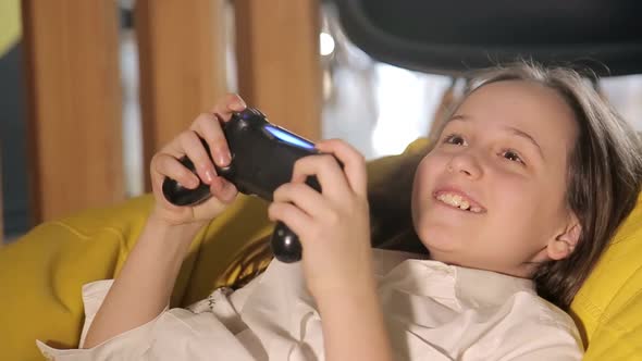 A Happy Child is Playing on a Game Console a Teenage Girl is Holding a Game Joystick alt
