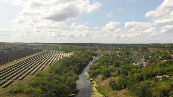 Aerial view of the Solar panels on a hill above the river alt