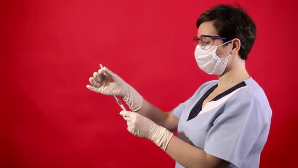 A Nurse in Sterile Gloves Holds an Injection Syringe To Prevent a Viral Infection. Coronavirus