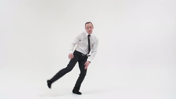 A Man in Office Clothes with a Tie Is Dancing a Break Dance on a White Background. A Male alt