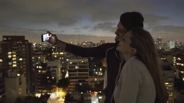Young couple taking selfie with smartphone